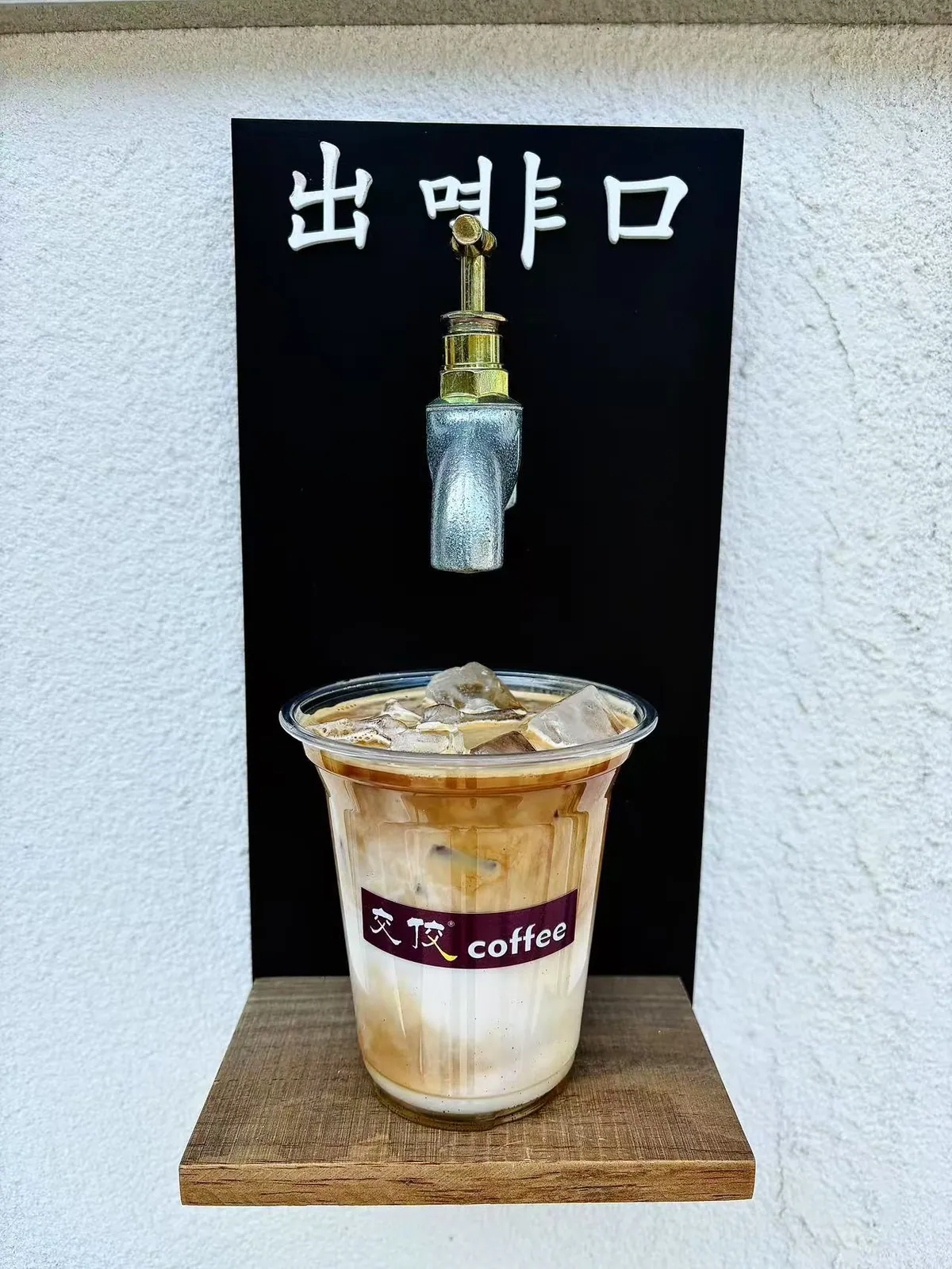 出品口前，一杯饮品放在小木台上